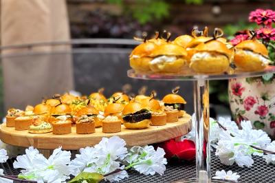 Sandwiches colorés empilés avec des garnitures variées, entourés de roquette et d'olives vertes.