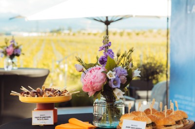 Plateau de canapés variés disposés sur une table en bois, décorée de fleurs et de bougies.