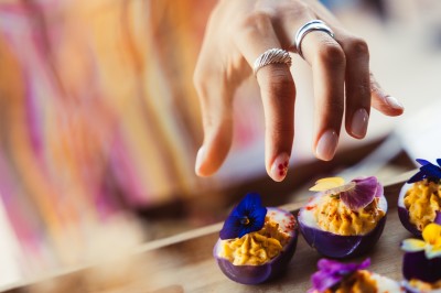 Plateau de canapés variés disposés sur une table en bois, décorée de fleurs et de bougies.