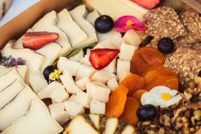 Plateau de canapés variés disposés sur une table en bois, décorée de fleurs et de bougies.