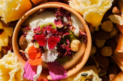 Plateau de canapés variés disposés sur une table en bois, décorée de fleurs et de bougies.