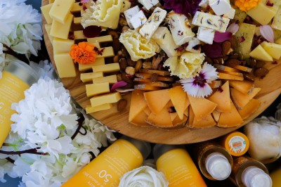 Plateau de canapés variés disposés sur une table en bois, décorée de fleurs et de bougies.