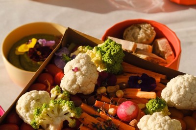 Plateau de canapés variés disposés sur une table en bois, décorée de fleurs et de bougies.