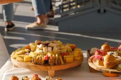Plateau de canapés variés disposés sur une table en bois, décorée de fleurs et de bougies.