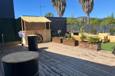 Vue aérienne d'un aménagement extérieur avec tables rondes, fontaine centrale, palmiers et espaces de détente.