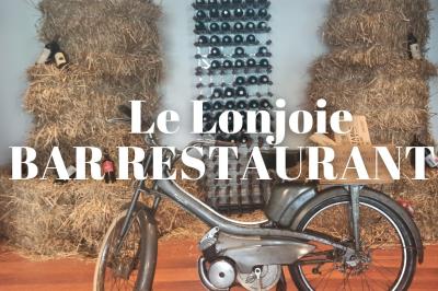 Bol de soupe de potiron garnie de croûtons, crème fraîche, persil et épices, posé sur une table en bois.