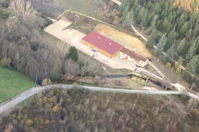 Un groupe de personnes photographiant un grand gâteau décoré, dans une salle remplie lors d'un événement festif.