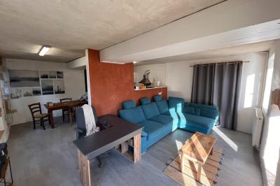 Salle de bain avec plafond en bois, carrelage coloré, douche avec rideau et lavabo sur meuble blanc.
