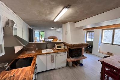 Salle de bain avec plafond en bois, carrelage coloré, douche avec rideau et lavabo sur meuble blanc.