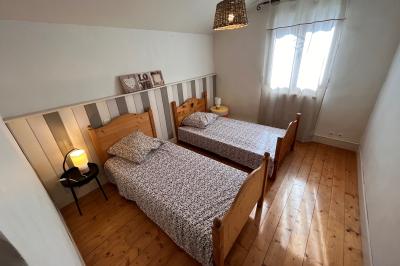 Salle de bain avec plafond en bois, carrelage coloré, douche avec rideau et lavabo sur meuble blanc.