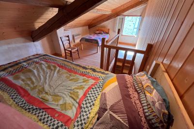 Salle de bain avec plafond en bois, carrelage coloré, douche avec rideau et lavabo sur meuble blanc.