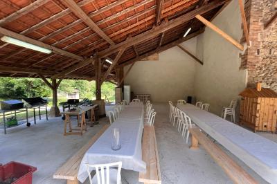 Salle de bain avec plafond en bois, carrelage coloré, douche avec rideau et lavabo sur meuble blanc.