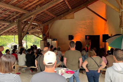 Salle de bain avec plafond en bois, carrelage coloré, douche avec rideau et lavabo sur meuble blanc.