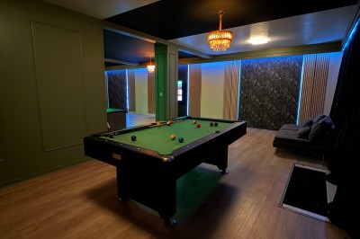 Poste de DJ avec platines, table de mixage et ordinateur portable dans une ambiance lumineuse violette et verte.