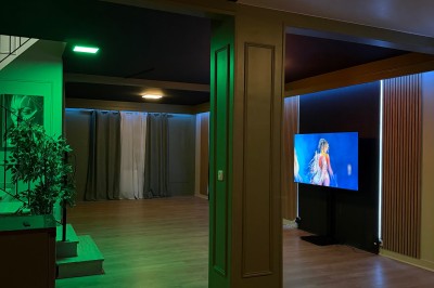 Poste de DJ avec platines, table de mixage et ordinateur portable dans une ambiance lumineuse violette et verte.