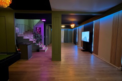 Poste de DJ avec platines, table de mixage et ordinateur portable dans une ambiance lumineuse violette et verte.