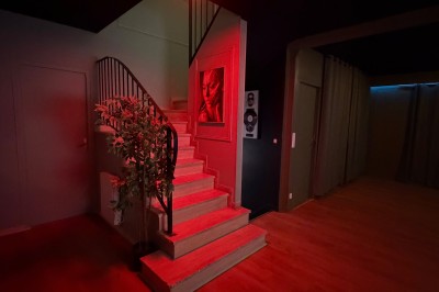 Poste de DJ avec platines, table de mixage et ordinateur portable dans une ambiance lumineuse violette et verte.