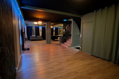 Poste de DJ avec platines, table de mixage et ordinateur portable dans une ambiance lumineuse violette et verte.