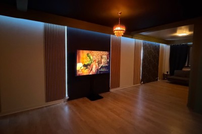 Poste de DJ avec platines, table de mixage et ordinateur portable dans une ambiance lumineuse violette et verte.