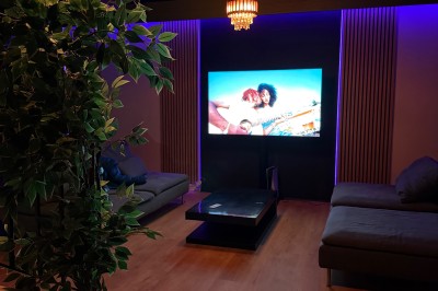 Poste de DJ avec platines, table de mixage et ordinateur portable dans une ambiance lumineuse violette et verte.