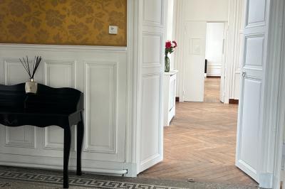 Vue aérienne d'un centre équestre avec une carrière, des cavaliers à cheval et des champs en arrière-plan.