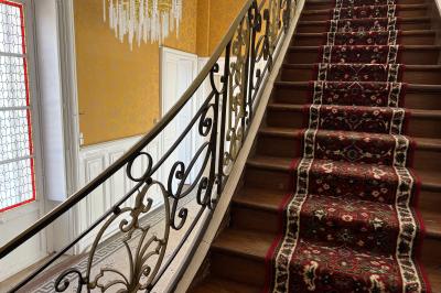 Vue aérienne d'un centre équestre avec une carrière, des cavaliers à cheval et des champs en arrière-plan.