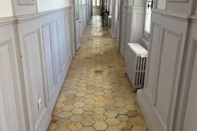 Vue aérienne d'un centre équestre avec une carrière, des cavaliers à cheval et des champs en arrière-plan.