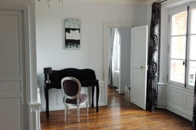 Vue aérienne d'un centre équestre avec une carrière, des cavaliers à cheval et des champs en arrière-plan.