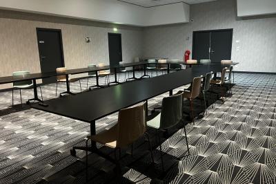 Avion suspendu dans un espace intérieur spacieux avec des écrans, des sièges et une décoration industrielle.