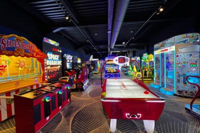 Avion suspendu dans un espace intérieur spacieux avec des écrans, des sièges et une décoration industrielle.