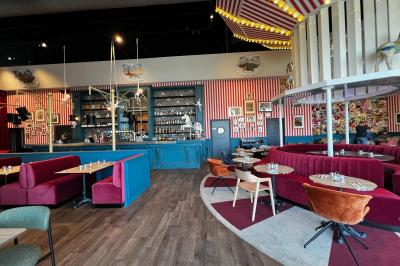 Avion suspendu dans un espace intérieur spacieux avec des écrans, des sièges et une décoration industrielle.