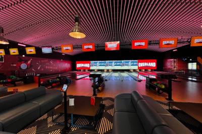 Un avion jaune suspendu au plafond d'un hall spacieux avec un comptoir d'accueil et des baies vitrées.