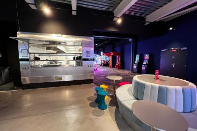 Un avion jaune suspendu au plafond d'un hall spacieux avec un comptoir d'accueil et des baies vitrées.