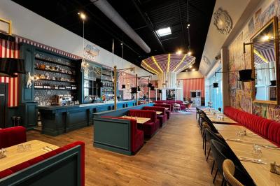 Un avion jaune suspendu au plafond d'un hall spacieux avec un comptoir d'accueil et des baies vitrées.