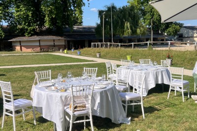 Chambre lumineuse avec lit double, draps blancs, coussins gris, bureau en bois et parquet en bois clair.