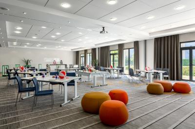 Salle de bain moderne avec lavabo en marbre, miroir éclairé, accessoires de toilette et douche en arrière-plan.