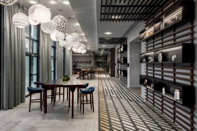 Salle de bain moderne avec lavabo en marbre, miroir éclairé, accessoires de toilette et douche en arrière-plan.