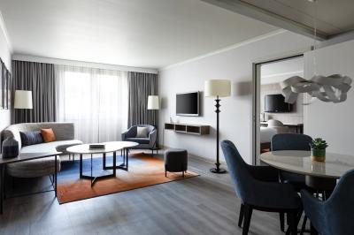 Salle de bain moderne avec lavabo en marbre, miroir éclairé, accessoires de toilette et douche en arrière-plan.