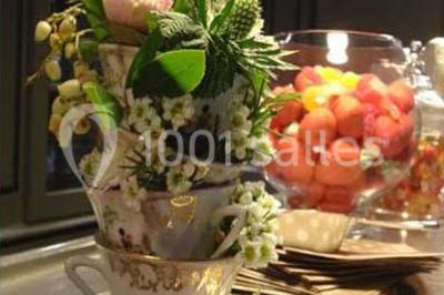 Lit double avec draps blancs, plaid bleu et tables de chevet avec lampes dans une chambre à la décoration rustique.