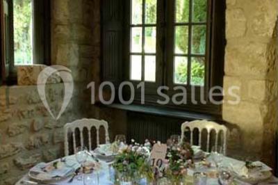 Lit double avec draps blancs, plaid bleu et tables de chevet avec lampes dans une chambre à la décoration rustique.