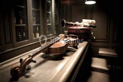 Lit double avec draps blancs, plaid bleu et tables de chevet avec lampes dans une chambre à la décoration rustique.