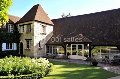 Lit double avec draps blancs, plaid bleu et tables de chevet avec lampes dans une chambre à la décoration rustique.