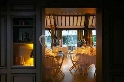 Lit double avec draps blancs, plaid bleu et tables de chevet avec lampes dans une chambre à la décoration rustique.