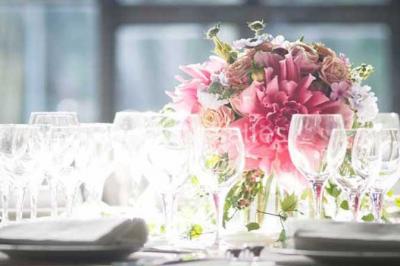 Lit double avec draps blancs, plaid bleu et tables de chevet avec lampes dans une chambre à la décoration rustique.
