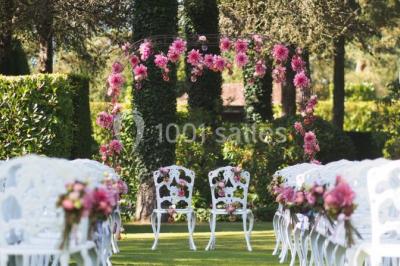 Lit double avec draps blancs, plaid bleu et tables de chevet avec lampes dans une chambre à la décoration rustique.