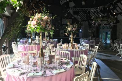 Lit double avec draps blancs, plaid bleu et tables de chevet avec lampes dans une chambre à la décoration rustique.