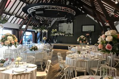 Lit double avec draps blancs, plaid bleu et tables de chevet avec lampes dans une chambre à la décoration rustique.