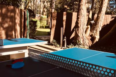 Lit double avec draps blancs, plaid bleu et tables de chevet avec lampes dans une chambre à la décoration rustique.