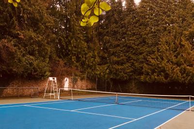 Lit double avec draps blancs, plaid bleu et tables de chevet avec lampes dans une chambre à la décoration rustique.