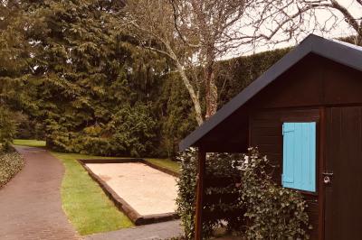 Lit double avec draps blancs, plaid bleu et tables de chevet avec lampes dans une chambre à la décoration rustique.